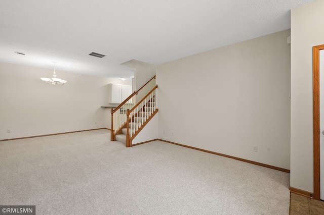 interior space with light carpet, a notable chandelier, and a textured ceiling