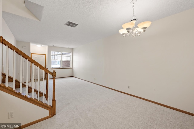 interior space with an inviting chandelier, carpet flooring, and a textured ceiling