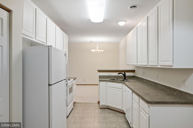 kitchen with decorative light fixtures, white cabinetry, sink, white appliances, and a textured ceiling