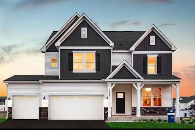 craftsman-style home featuring a garage, stone siding, aphalt driveway, and board and batten siding