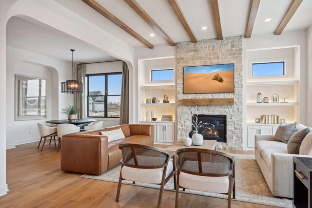 4718 Ordell Trl N, Stillwater, MN 55082 - living room featuring arched walkways, a fireplace, light wood finished floors, beam ceiling, and recessed lighting
