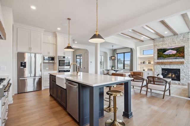 4718 Ordell Trl N, Stillwater, MN 55082 - kitchen featuring appliances with stainless steel finishes, a sink, arched walkways, light countertops, and open floor plan