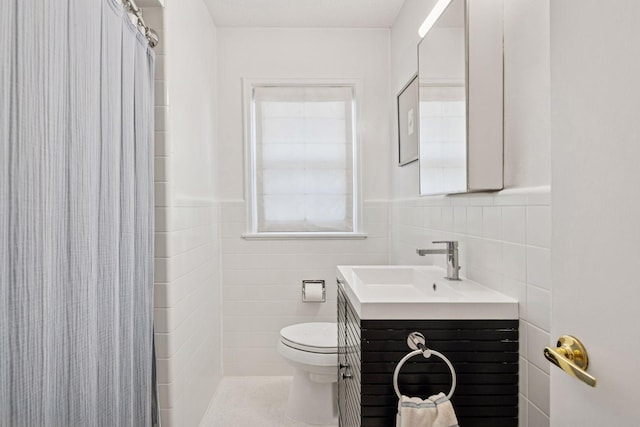 full bathroom featuring a wainscoted wall, toilet, a shower with curtain, tile walls, and vanity