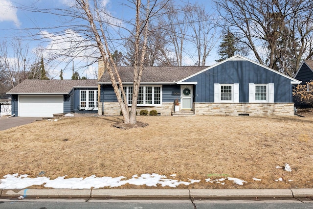 ranch-style home featuring aphalt driveway, stone siding, board and batten siding, and a garage