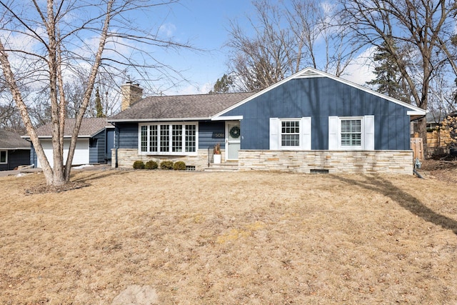 view of front of house with a shingled roof, a front yard, a chimney, a garage, and stone siding