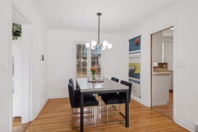 dining room with visible vents, baseboards, a chandelier, and light wood finished floors