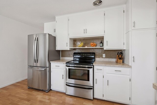 kitchen with decorative backsplash, light countertops, visible vents, and appliances with stainless steel finishes