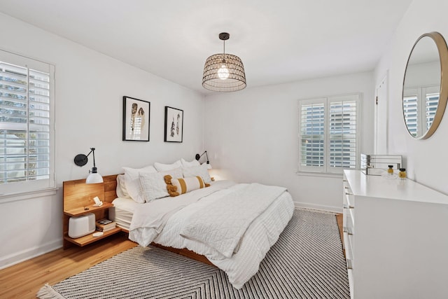 bedroom with baseboards and light wood-style flooring