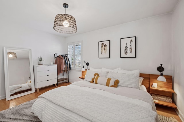 bedroom with baseboards and wood finished floors