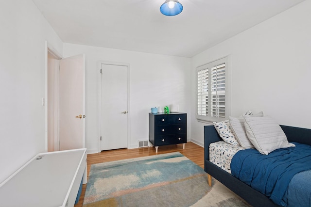 bedroom featuring visible vents and wood finished floors