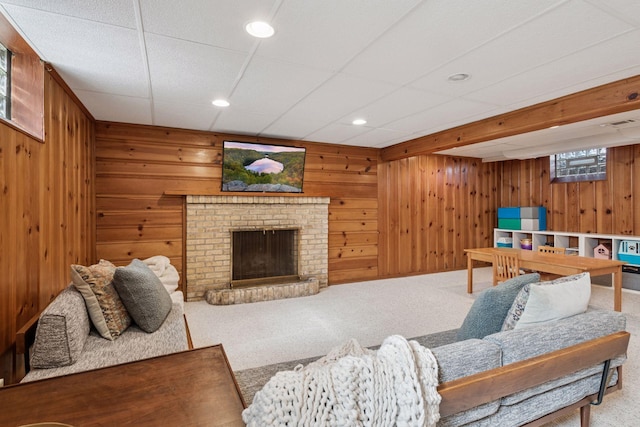 carpeted living area with recessed lighting, wood walls, and a fireplace