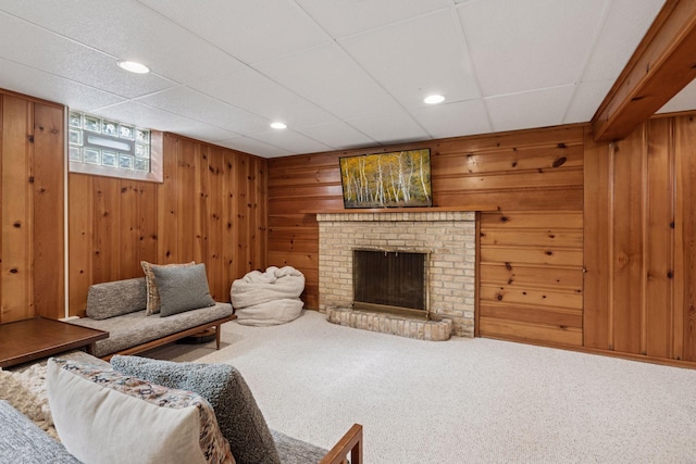 carpeted living room with recessed lighting, wooden walls, and a fireplace