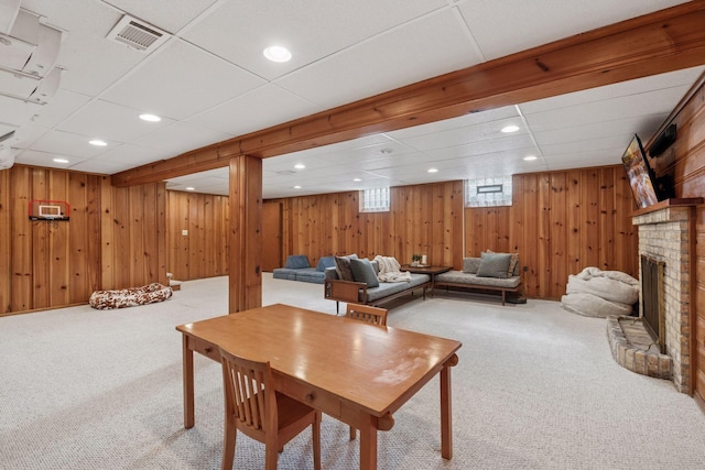 carpeted dining space featuring recessed lighting, visible vents, wood walls, and a fireplace