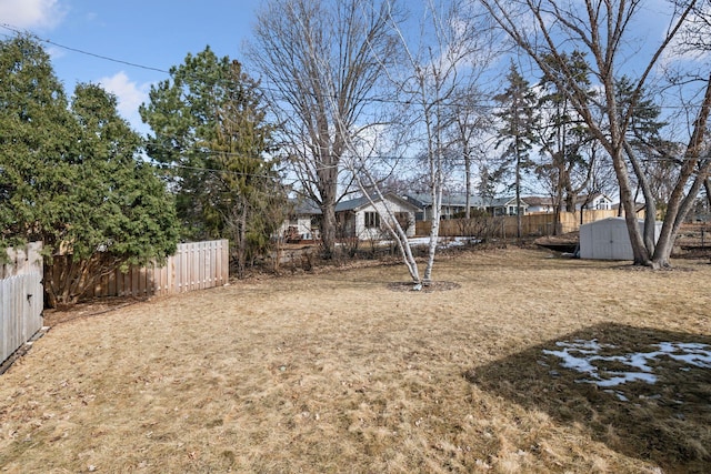 view of yard with an outdoor structure, a storage unit, and fence