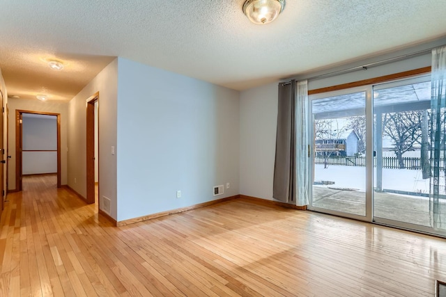 spare room with light hardwood / wood-style flooring and a textured ceiling