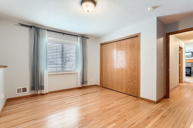 unfurnished bedroom with a closet and light hardwood / wood-style flooring