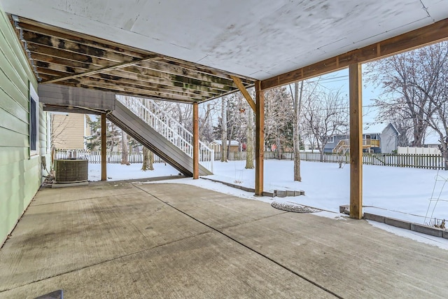 snow covered patio featuring cooling unit