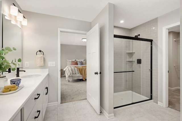 bathroom featuring vanity, a shower with shower door, tile patterned flooring, and a textured ceiling