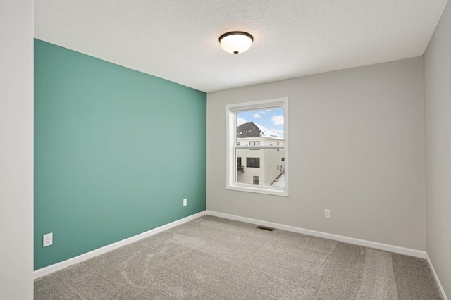 empty room with a textured ceiling and carpet