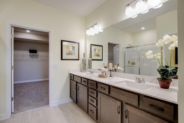 bathroom featuring vanity, a shower with shower door, and wood-type flooring