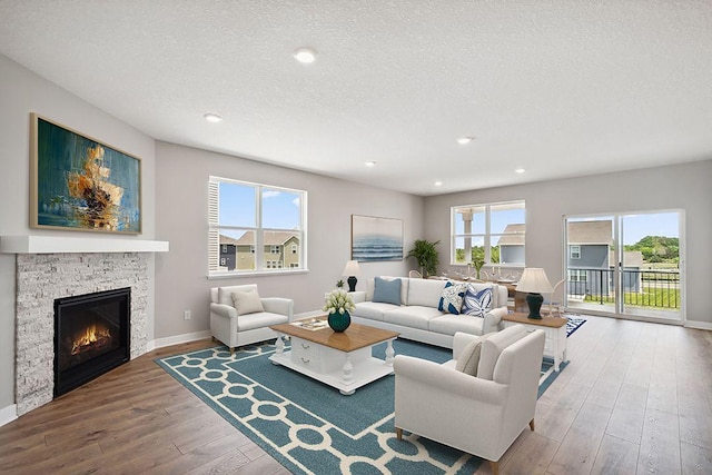 1683 Oak Creek Ct, Chaska, MN 55318 - living room featuring hardwood / wood-style flooring, a textured ceiling, a fireplace, healthy amount of natural light, and baseboards