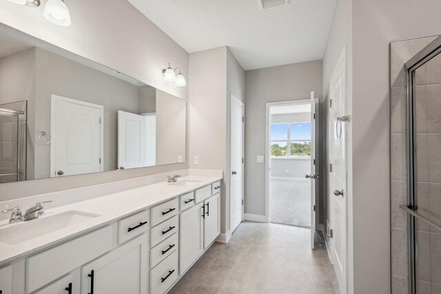 1683 Oak Creek Ct, Chaska, MN 55318 - bathroom featuring a stall shower, double vanity, baseboards, and concrete flooring