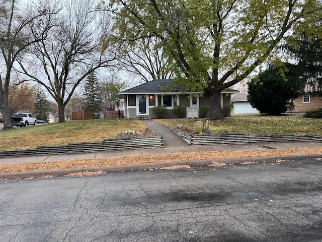 view of front of property featuring an attached garage and fence