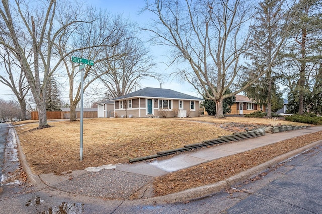 ranch-style house with a front yard and fence