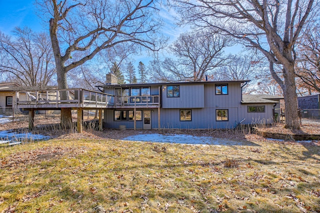 back of property with a wooden deck and a chimney