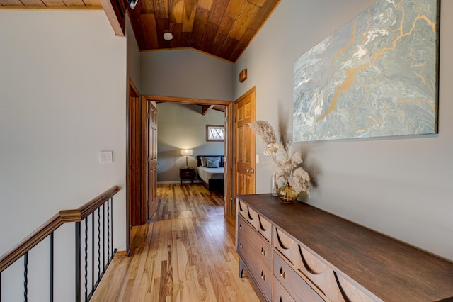 hallway featuring light wood finished floors, wood ceiling, and vaulted ceiling