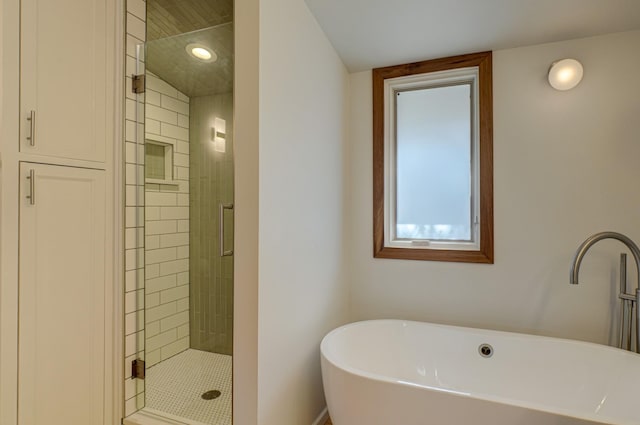 bathroom featuring a sink, a shower stall, and a freestanding bath