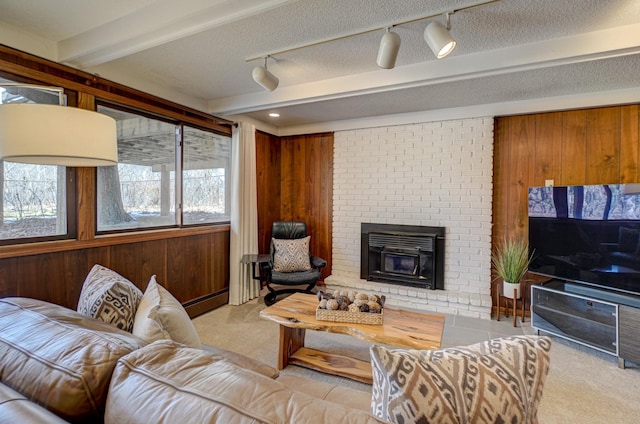 living room featuring beam ceiling, wooden walls, a textured ceiling, and carpet floors