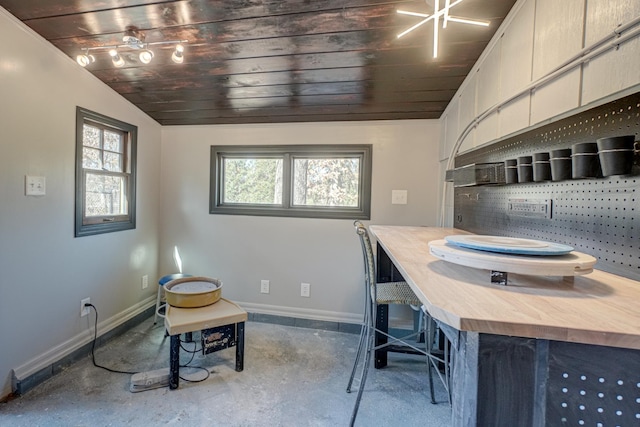 office area with a wealth of natural light, baseboards, and vaulted ceiling