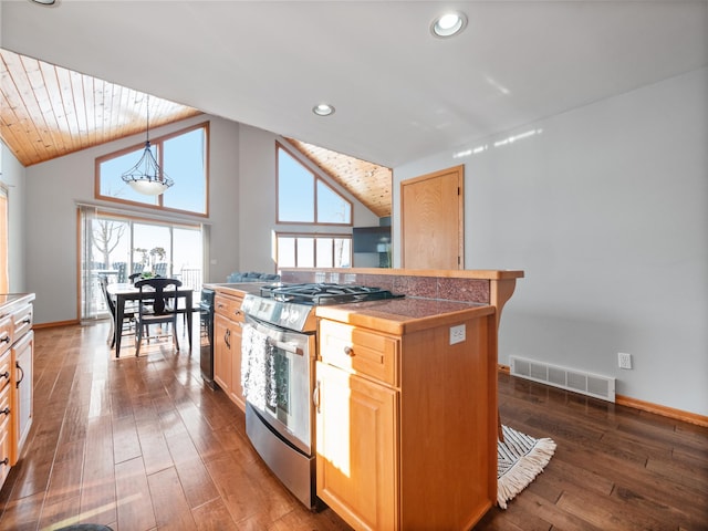 kitchen featuring decorative light fixtures, dark wood finished floors, lofted ceiling, visible vents, and stainless steel gas range oven