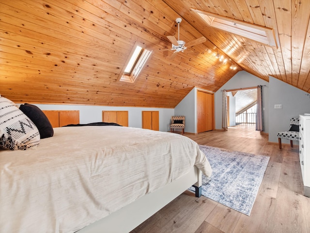 bedroom with wooden ceiling, light wood-style floors, and vaulted ceiling with skylight