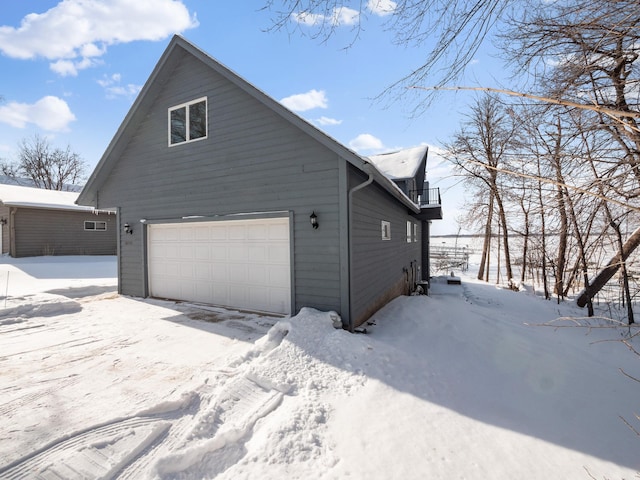 snow covered property with a garage