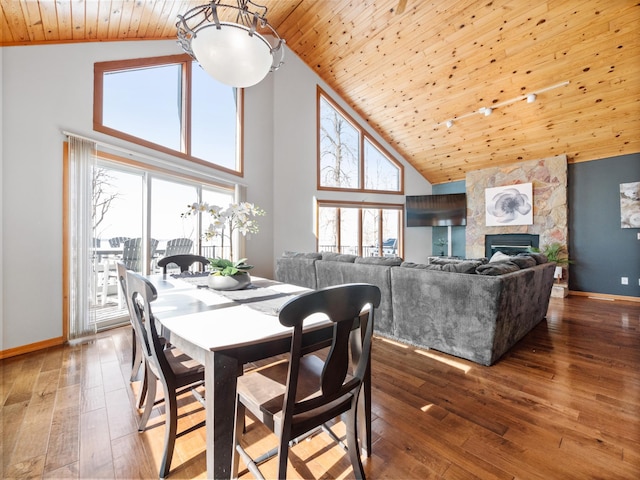 dining area with baseboards, wood finished floors, wood ceiling, and a healthy amount of sunlight