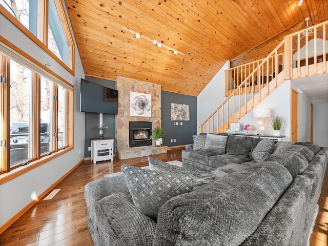 living area featuring high vaulted ceiling, wooden ceiling, wood finished floors, baseboards, and stairs