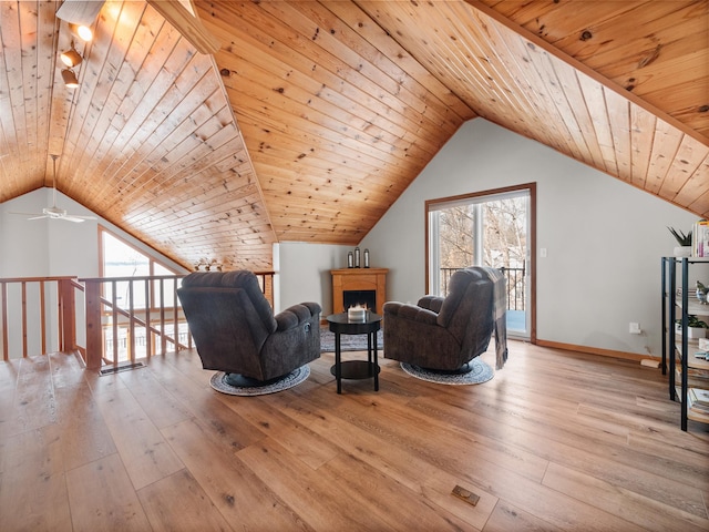 living area with light wood finished floors, wood ceiling, baseboards, and vaulted ceiling