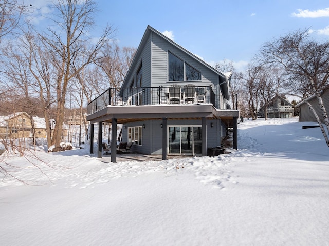 snow covered rear of property featuring a deck