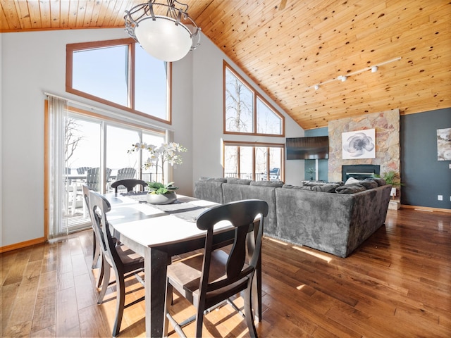 dining space featuring wood ceiling, baseboards, wood-type flooring, and high vaulted ceiling