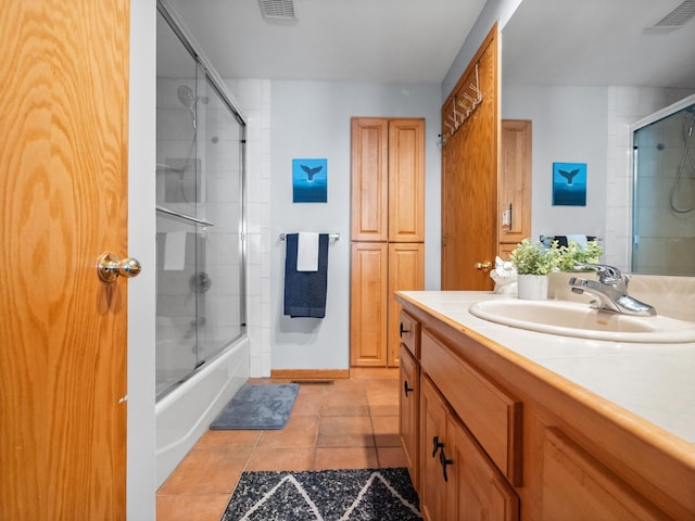 full bath featuring combined bath / shower with glass door, visible vents, vanity, and tile patterned flooring
