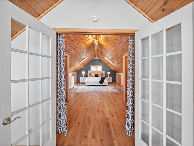 corridor featuring light wood-style flooring, wood ceiling, and lofted ceiling
