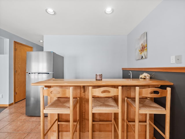 interior space with light tile patterned floors, recessed lighting, and freestanding refrigerator