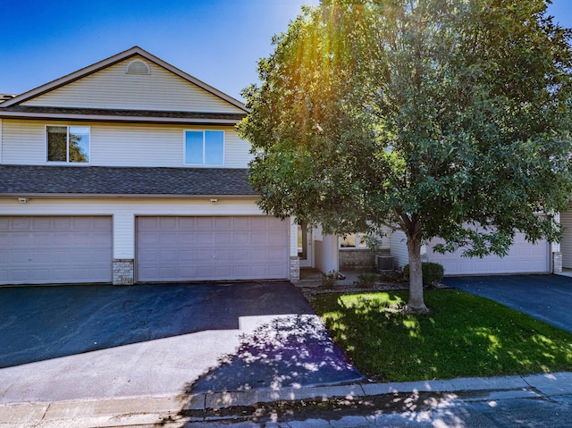 view of front of home featuring a garage and central air condition unit