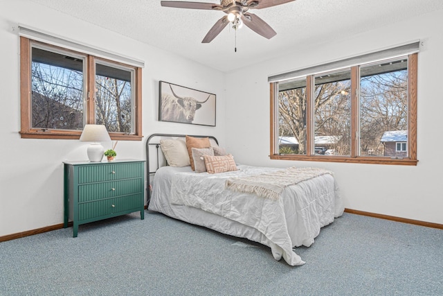 carpeted bedroom with a ceiling fan, baseboards, and a textured ceiling