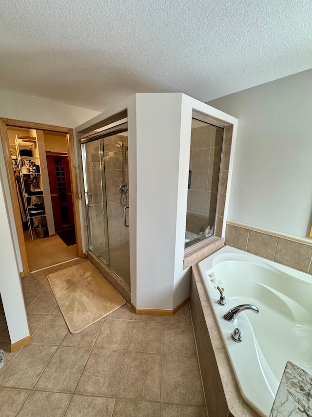 bathroom featuring a stall shower, tile patterned flooring, a walk in closet, and a bath