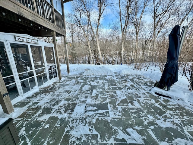 yard layered in snow with a sunroom