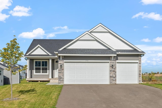 view of front of property featuring a garage, driveway, stone siding, roof with shingles, and a front yard