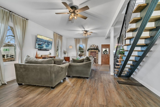 living room featuring stairway, baseboards, and wood finished floors